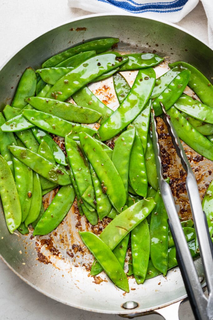 Cooking snow peas in a hot skillet.