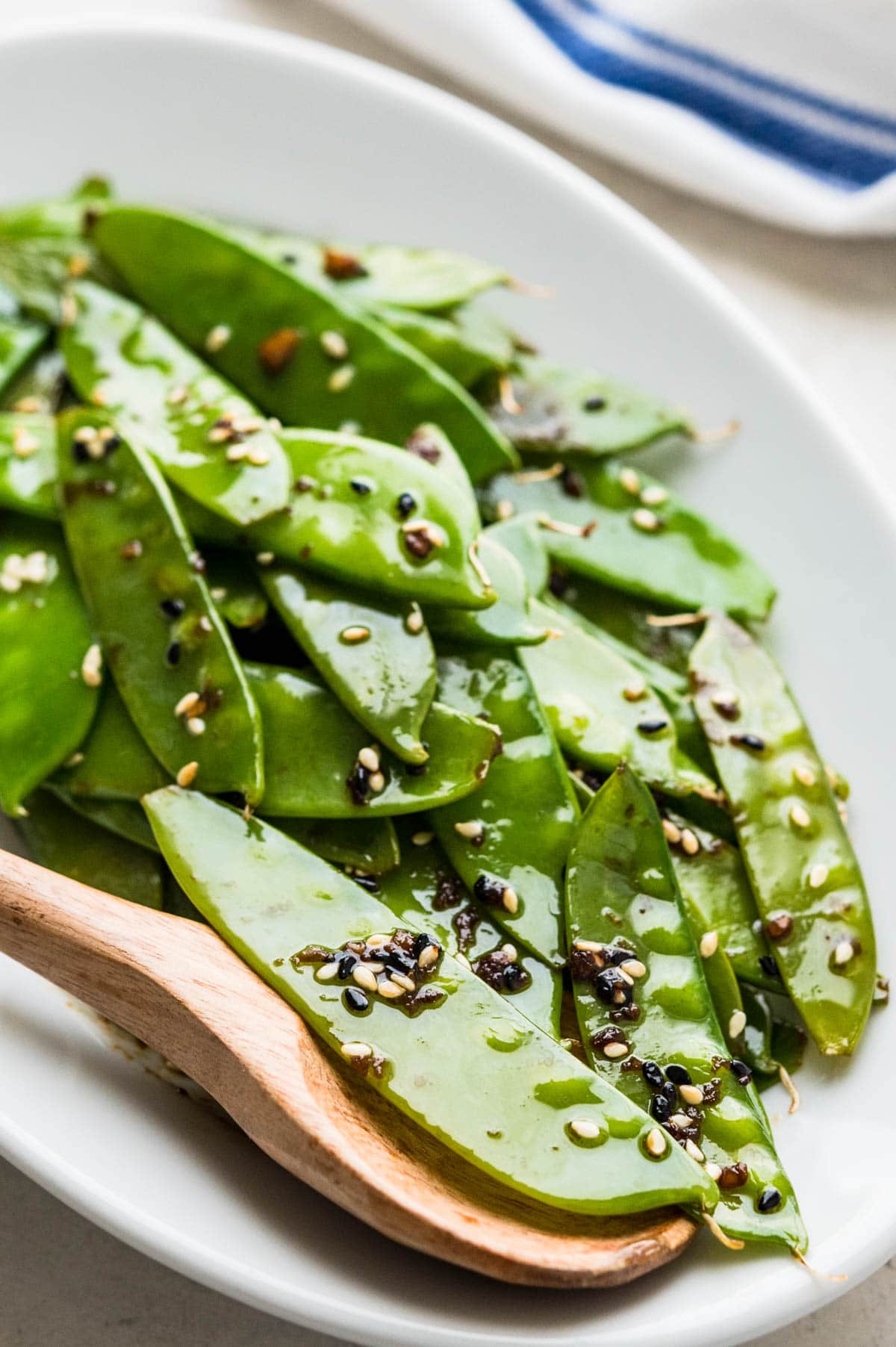 Serving cooked snow peas with sesame seeds.