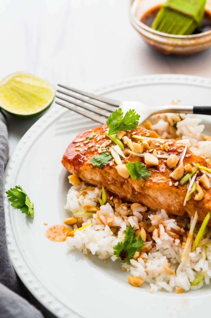 Serving the seared salmon over rice with peanuts, cilantro and lime.