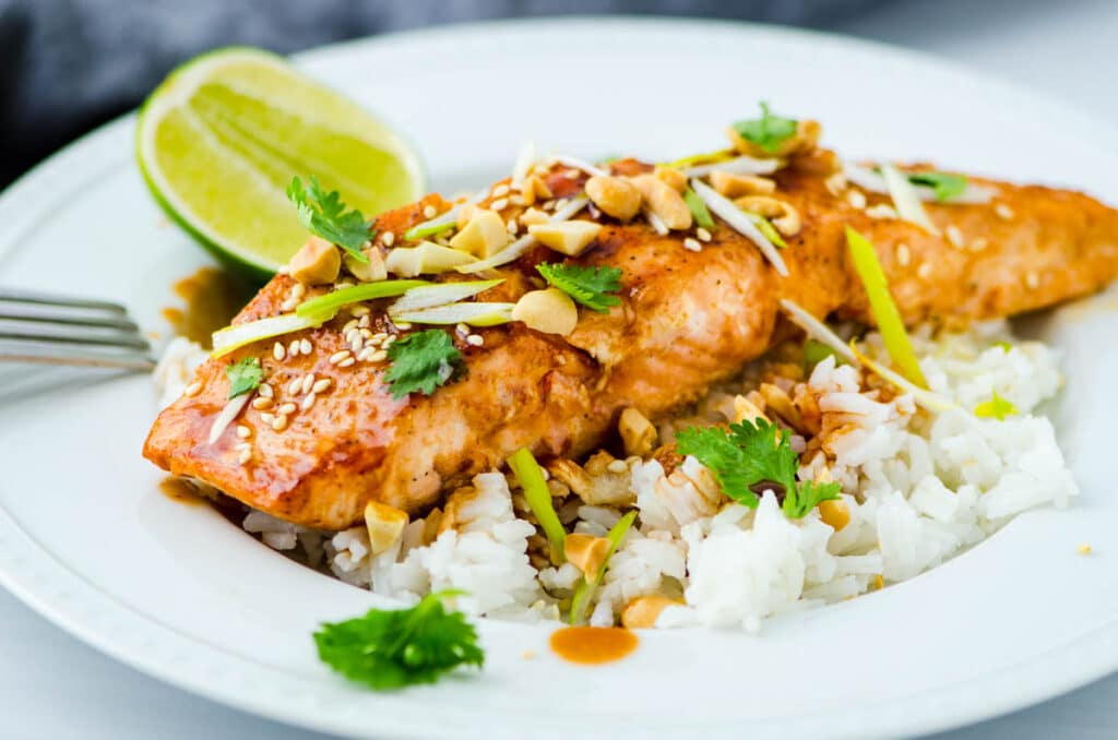 a serving of pan seared salmon with Asian glaze over rice.