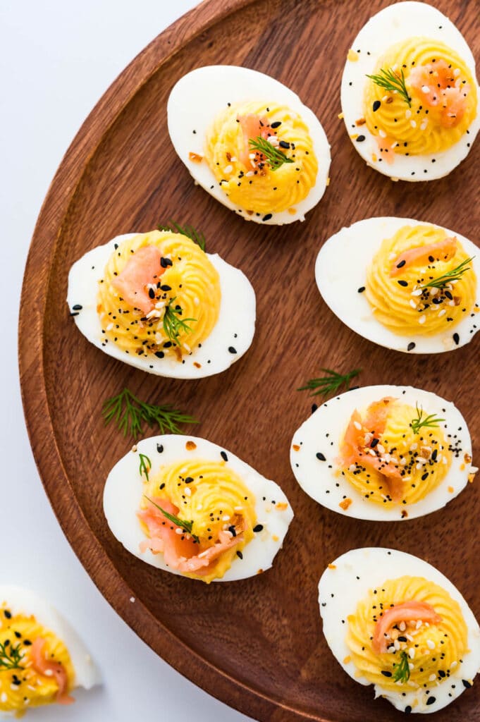 Serving smoked salmon deviled eggs on a wooden platter.