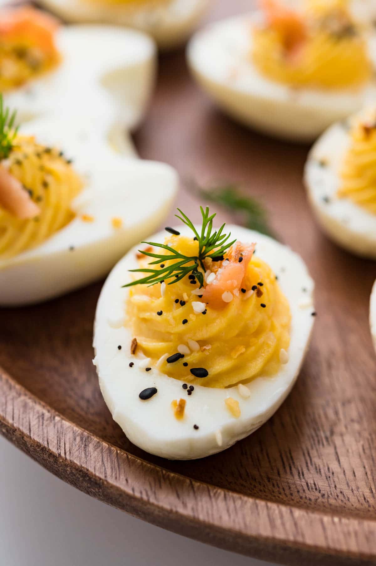 smoked salmon deviled eggs on a wooden platter.