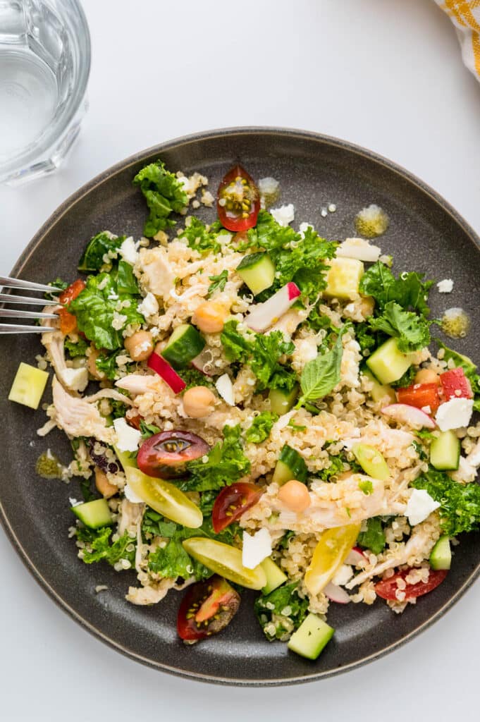 healthy chicken quinoa salad on a plate with fork.