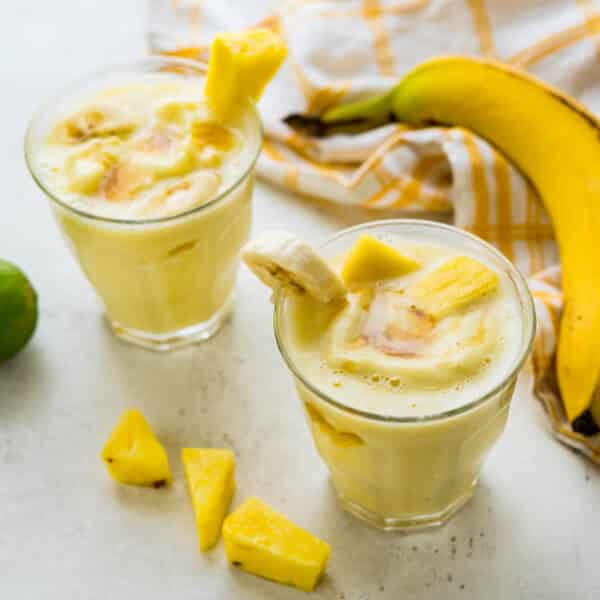 pineapple banana smoothie with fruit garnishes.