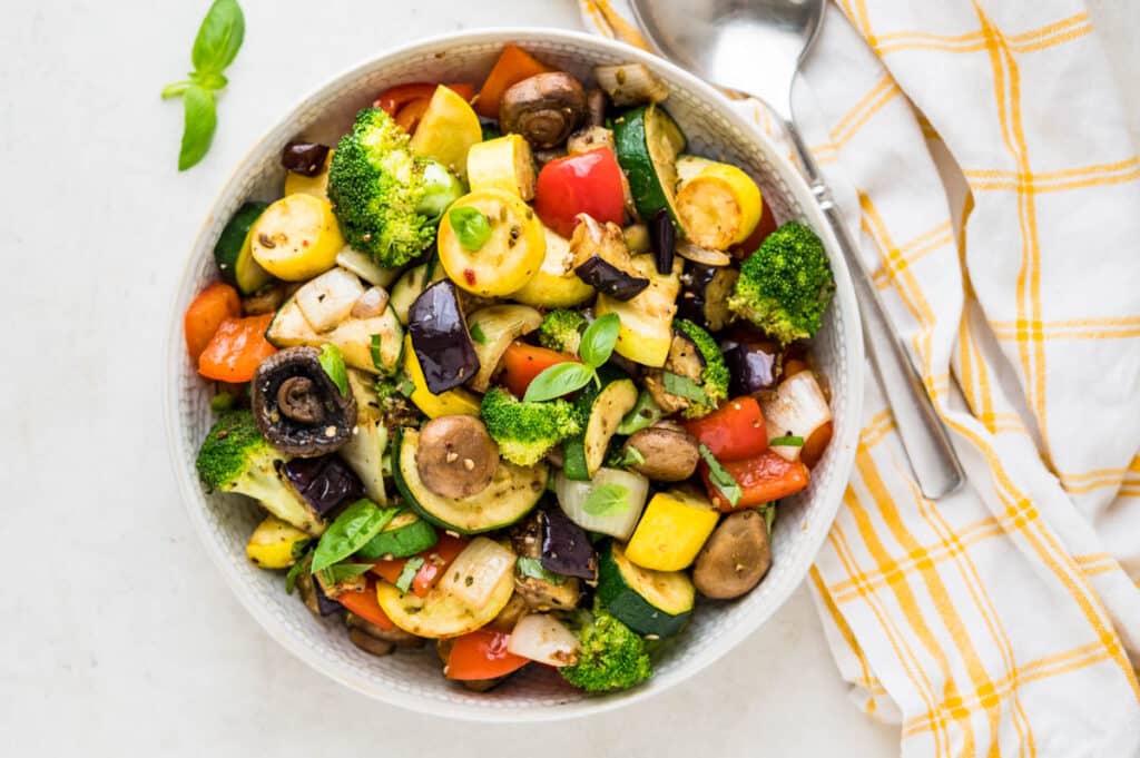 a bowl of the vegetable medley with a spoon.