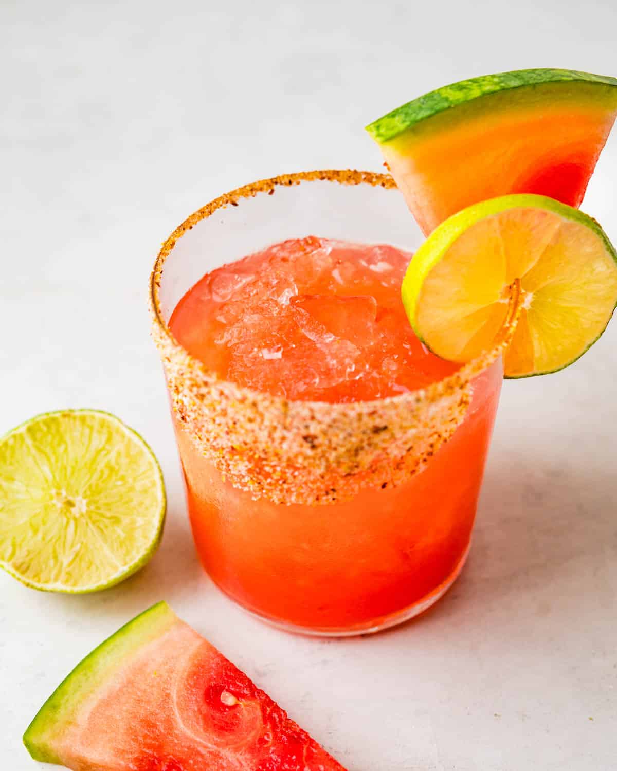 Serving watermelon margarita with a lime slice.