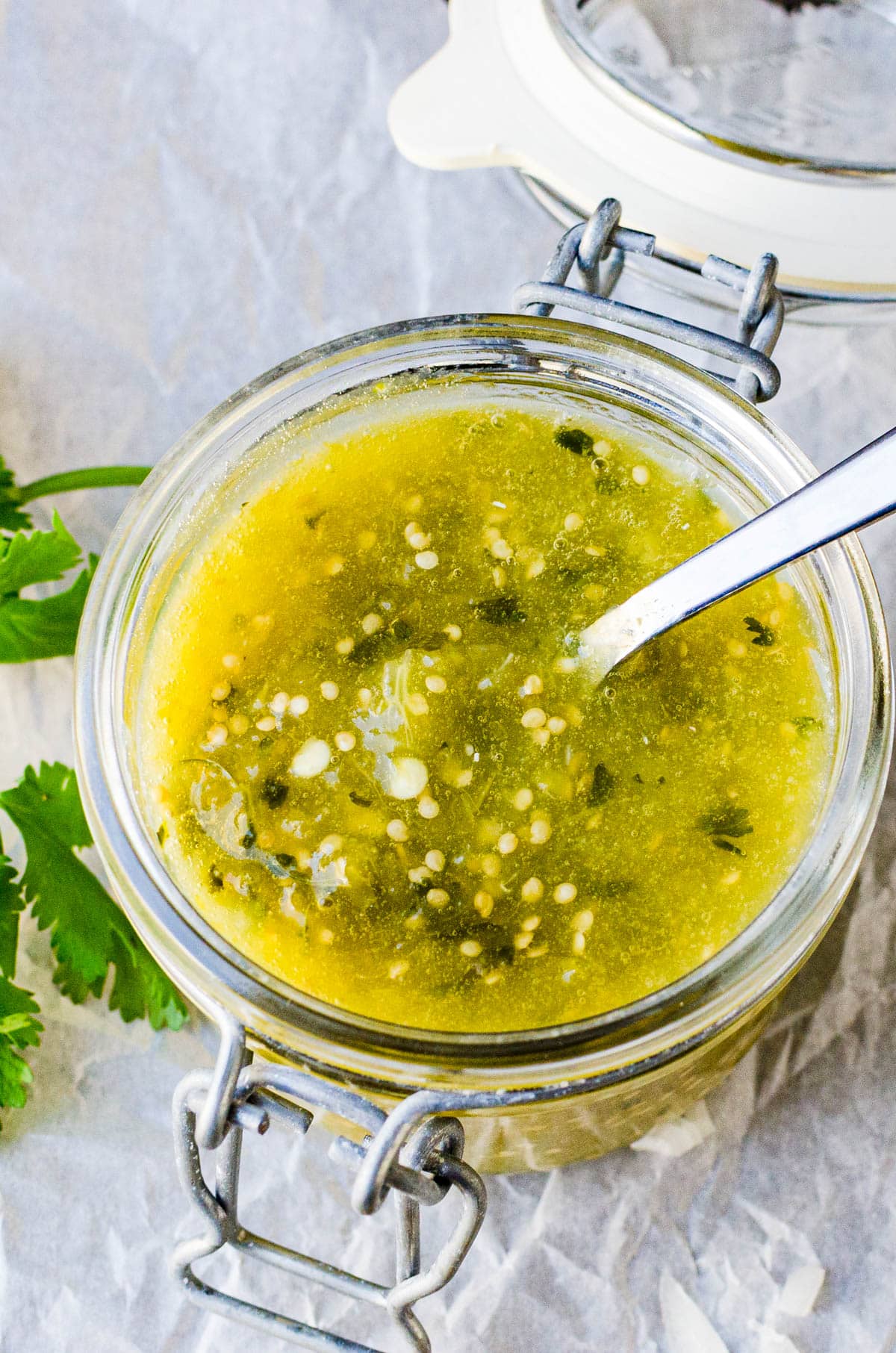homemade salsa verde in a canning jar with a spoon.