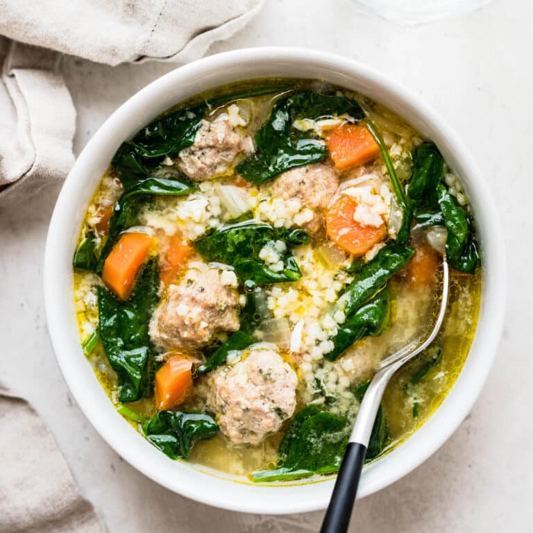 a bowl of homemade Italian wedding soup with meatballs, vegetables and pasta.