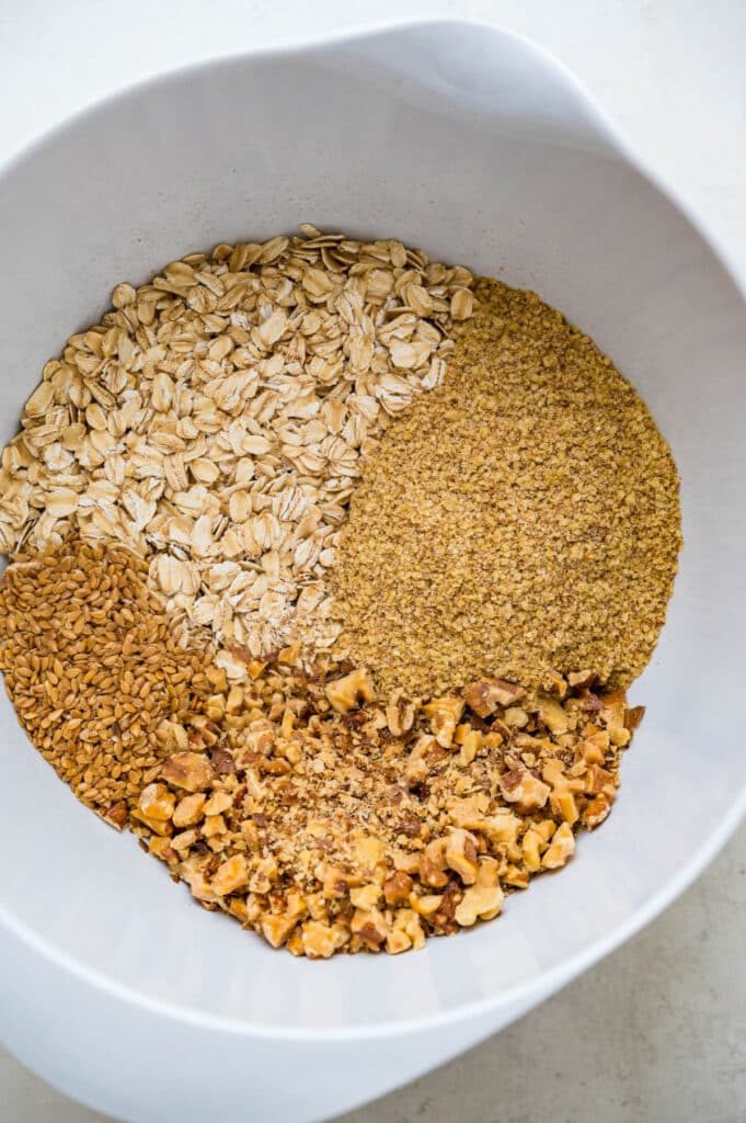 mixing oats, flax, wheat germ and toasted walnuts in a bowl.