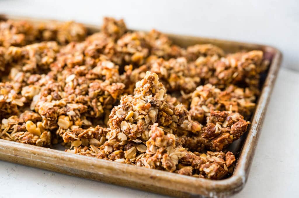 breaking the granola into clusters.