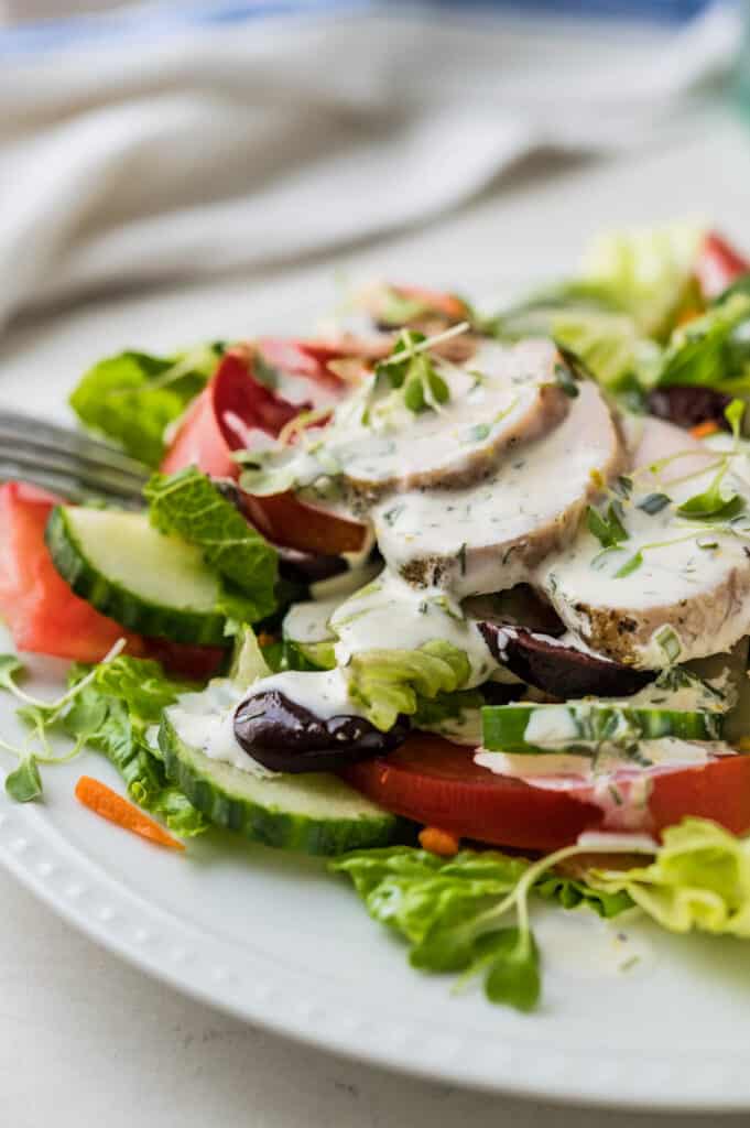 A plate of house salad garnished with a drizzle of the buttermilk dressing recipe.