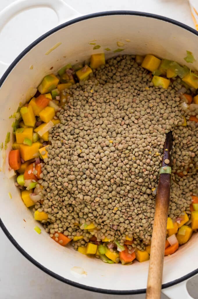 adding dry lentils to the sautéed vegetables. 