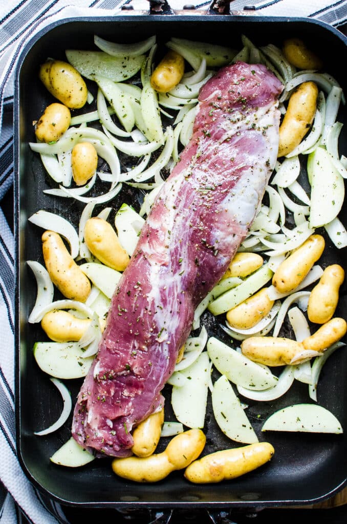 arranging the tenderloin and vegetables in a roasting pan.