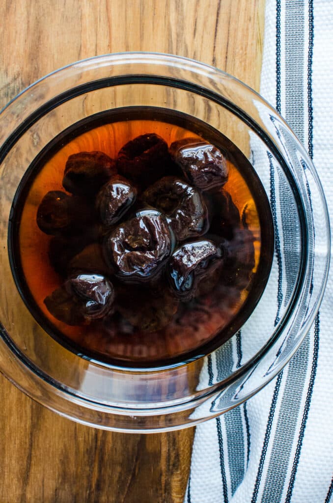 soaking pitted prunes in port wine.