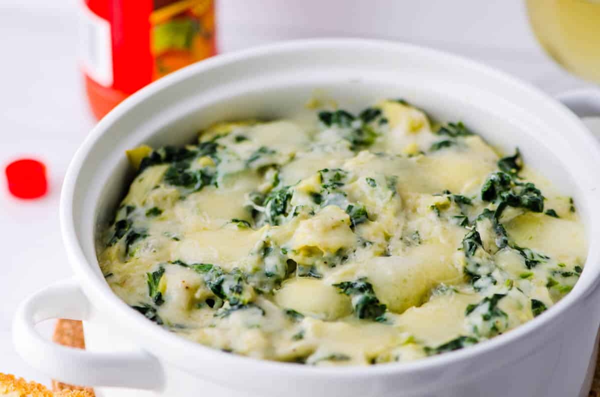 a small casserole dish with just baked spinach artichoke dip.