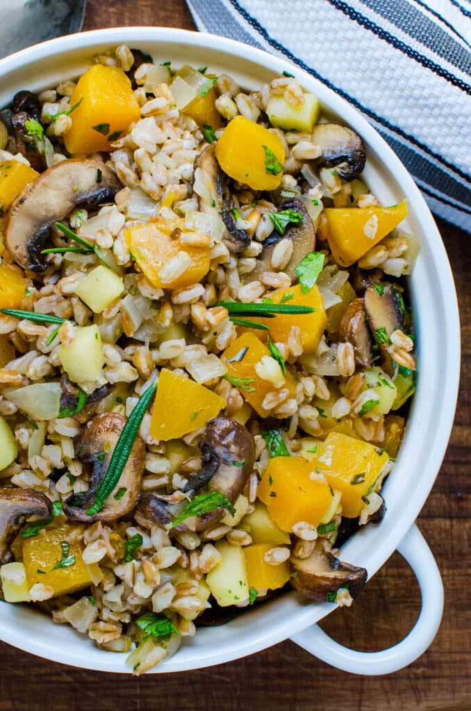 a fall farro recipe with butternut squash and apples in a serving bowl.