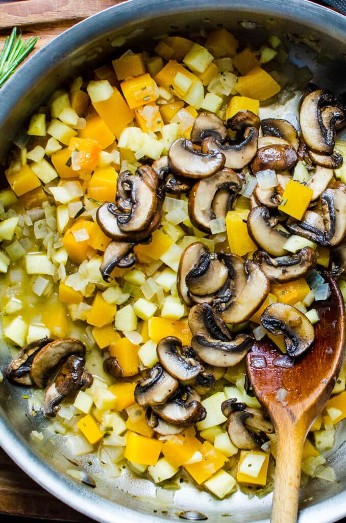 adding mushrooms back to the pan.