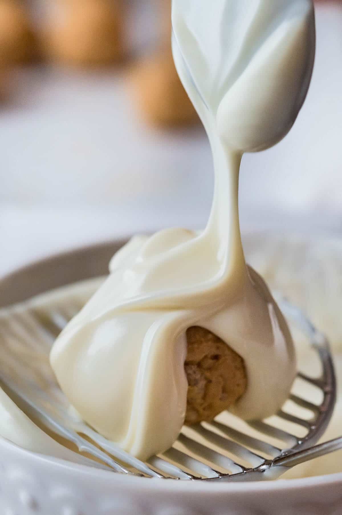 drizzling white chocolate over the peanut butter balls.