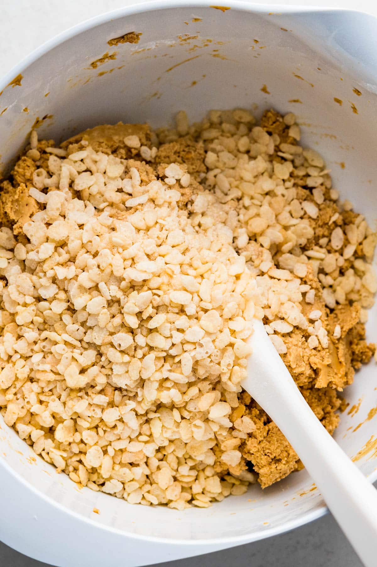 adding rice krispies to the peanut butter mixture.