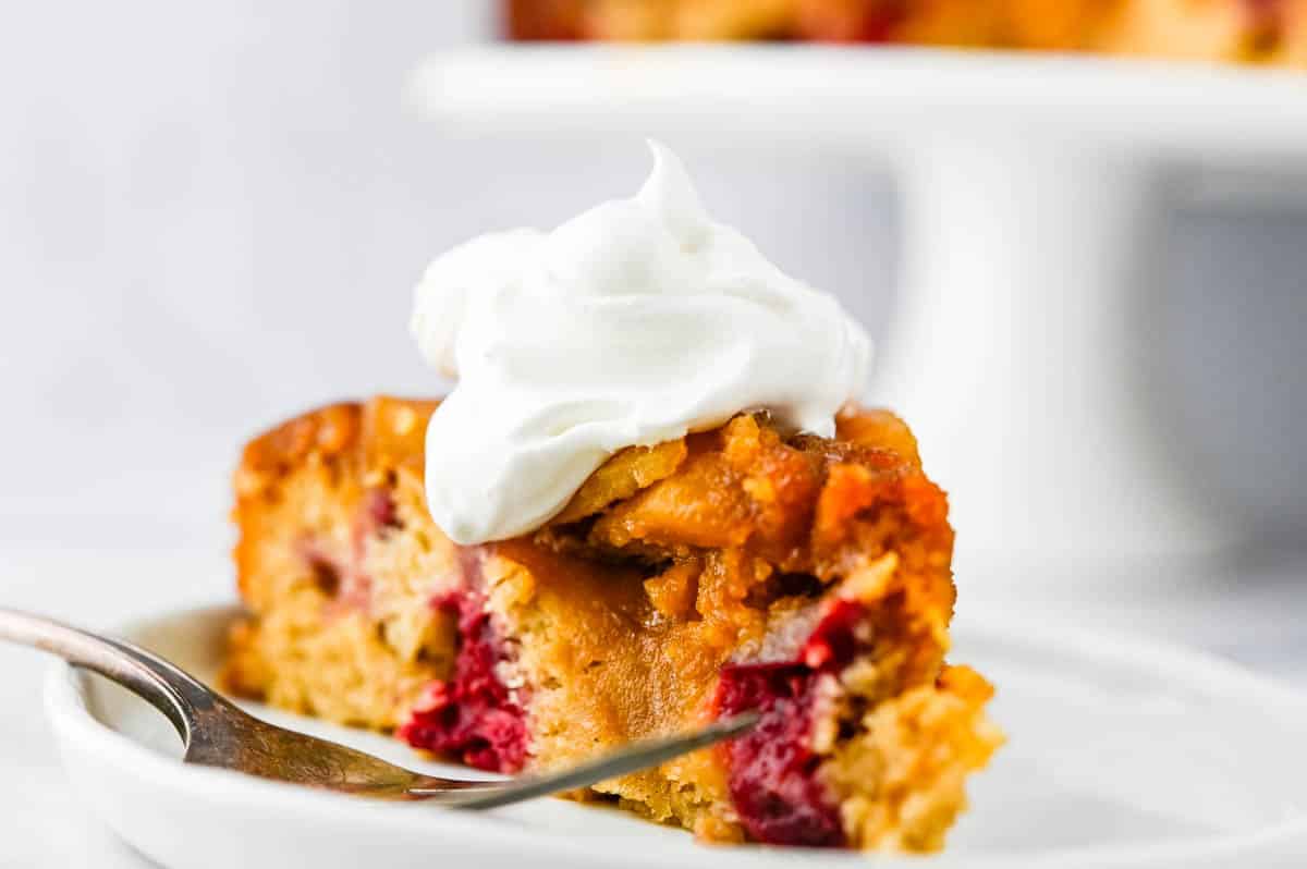 A slice of cranberry pear upside down cake on a plate.