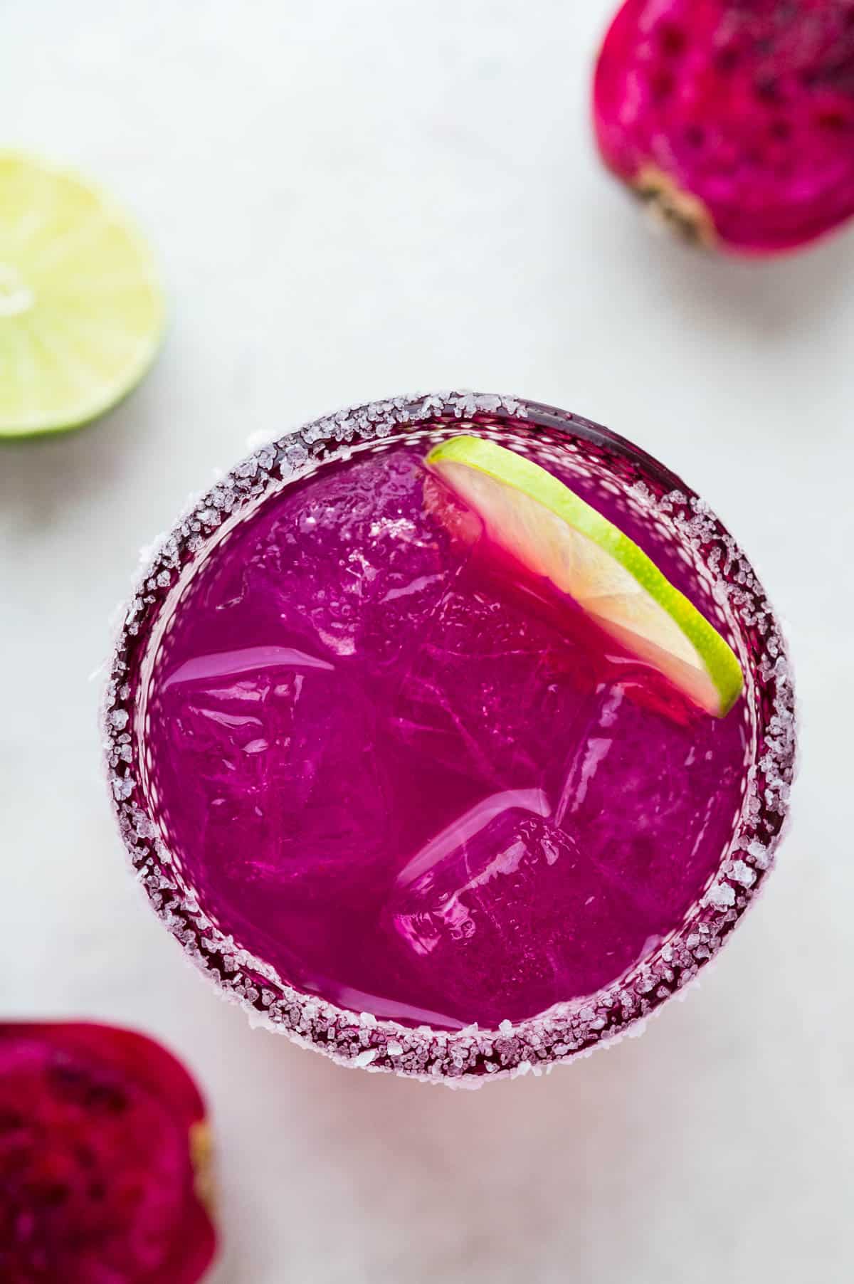 an overhead shot of prickly pear margarita and the salted rim of the glass.