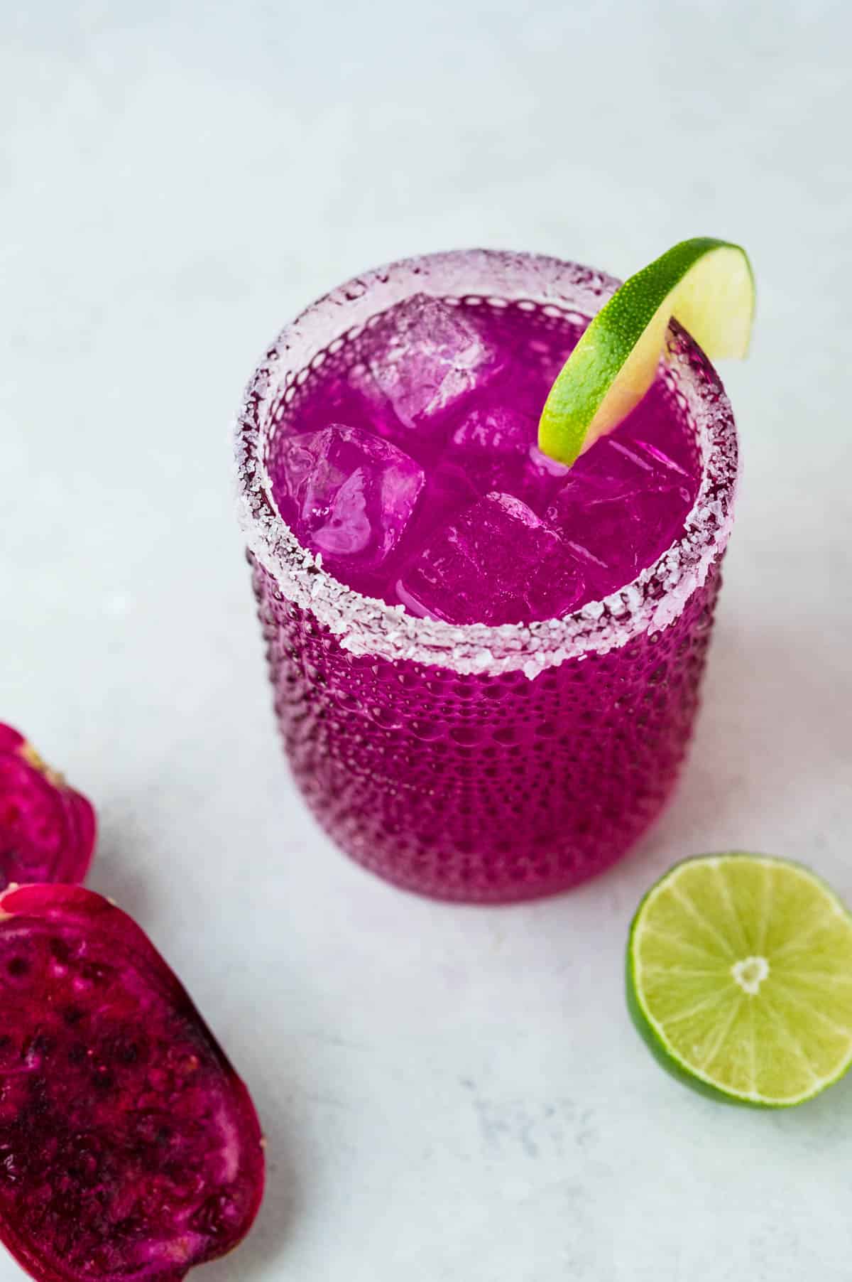 prickly pear margarita with a lime wedge.