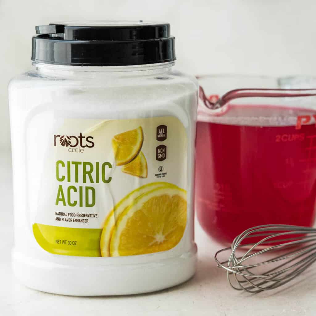 a container of citric acid next to the prickly pear syrup.