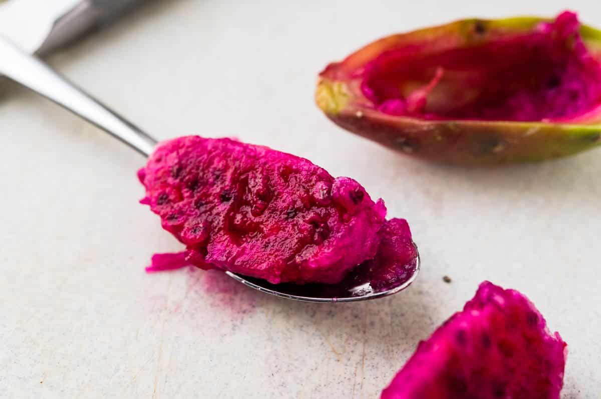 scooping flesh from the prickly pear with a spoon.