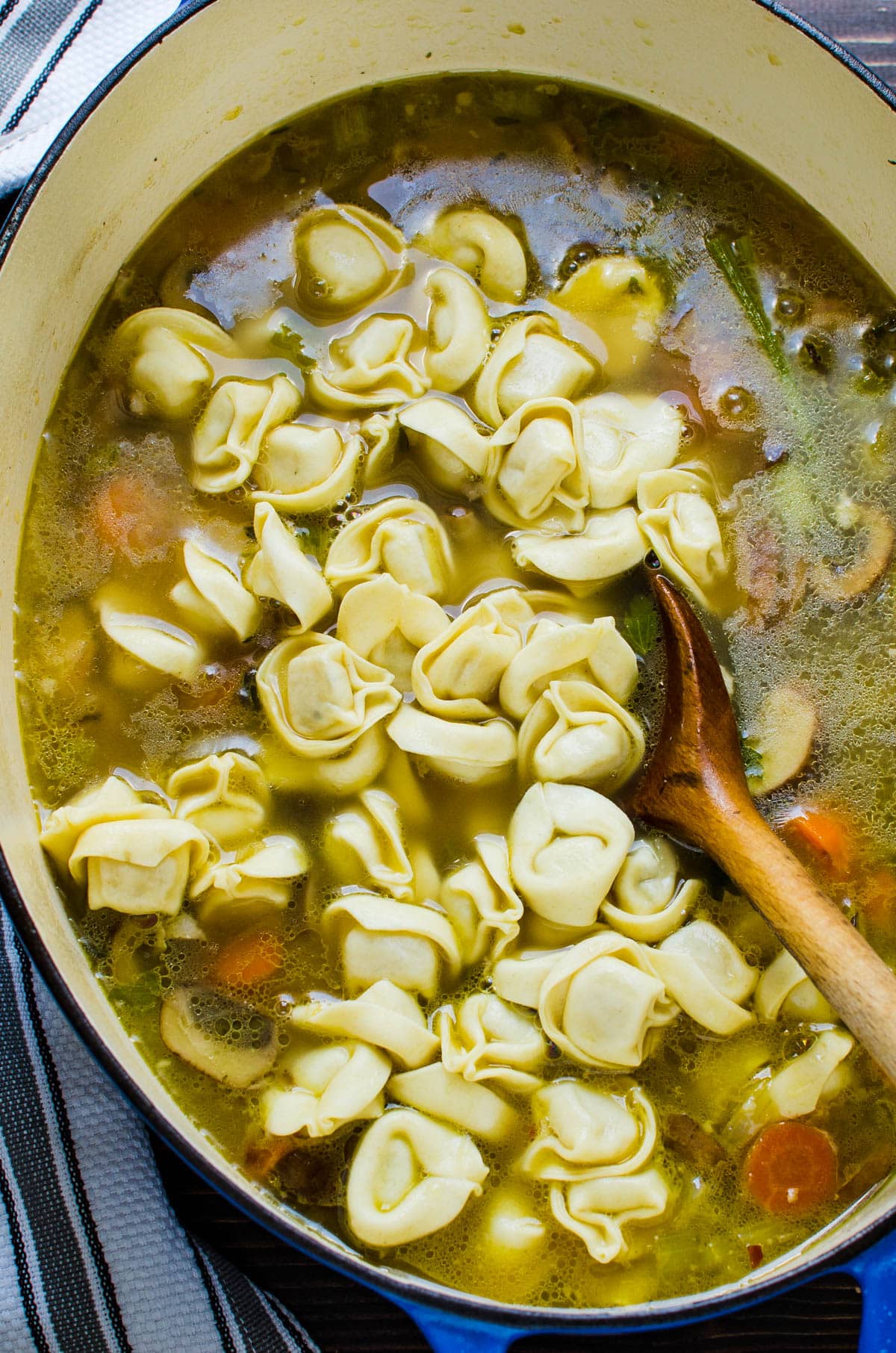 adding tortellini pasta to the soup.
