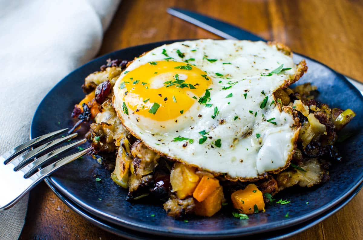 crusty stuffing hash with an egg on top and a fork.