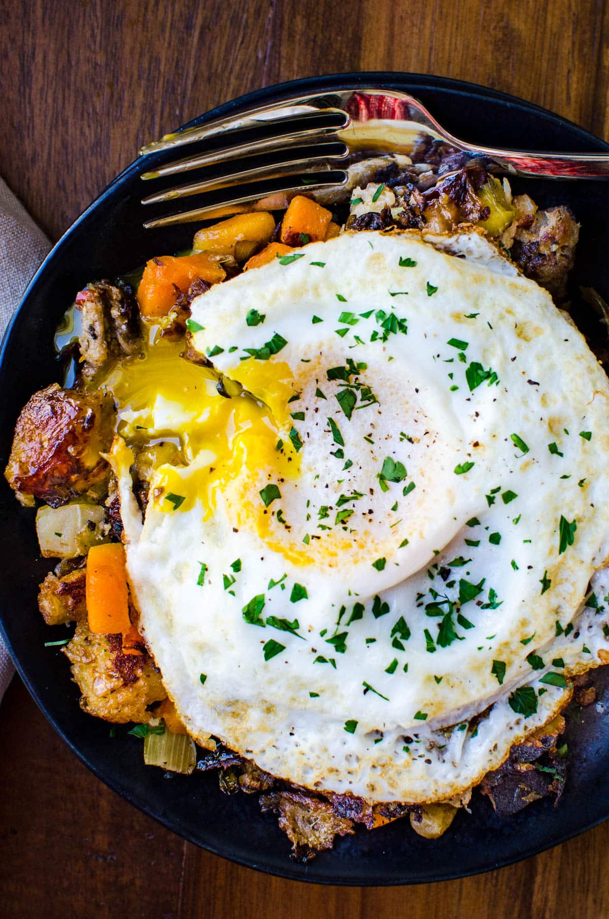 the yolk oozing over the stuffing hash on a plate. 