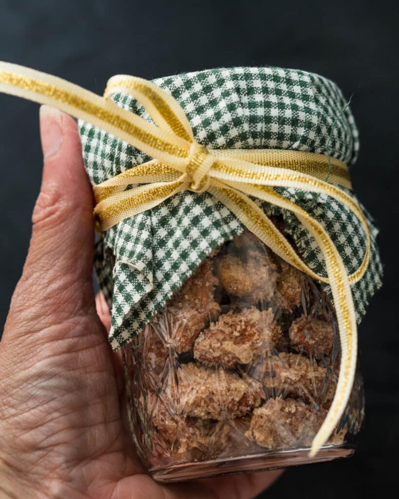 Cinnamon roasted almonds in a 2 cup canning jar with a ribbon tied around the top for gifting.