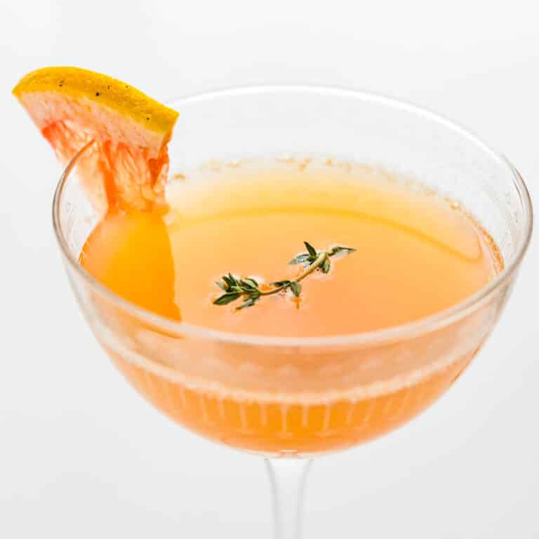 A coupe glass filled with grapefruit mimosa.