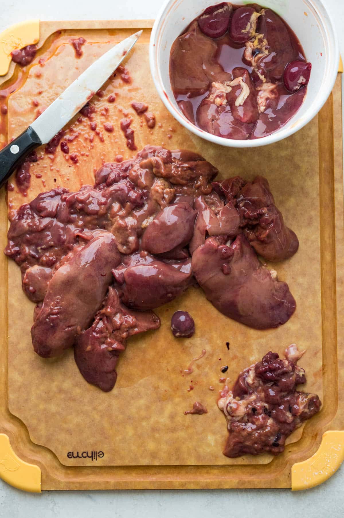 cleaning chicken livers to remove fat and connective tissues.