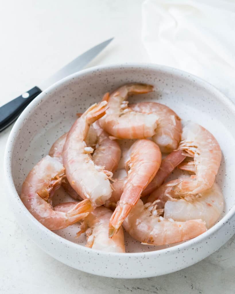 A bowl filled with jumbo shrimp.