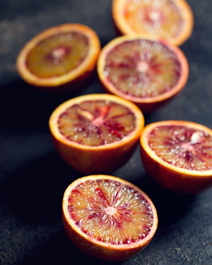 Sliced blood oranges on a dark background. 