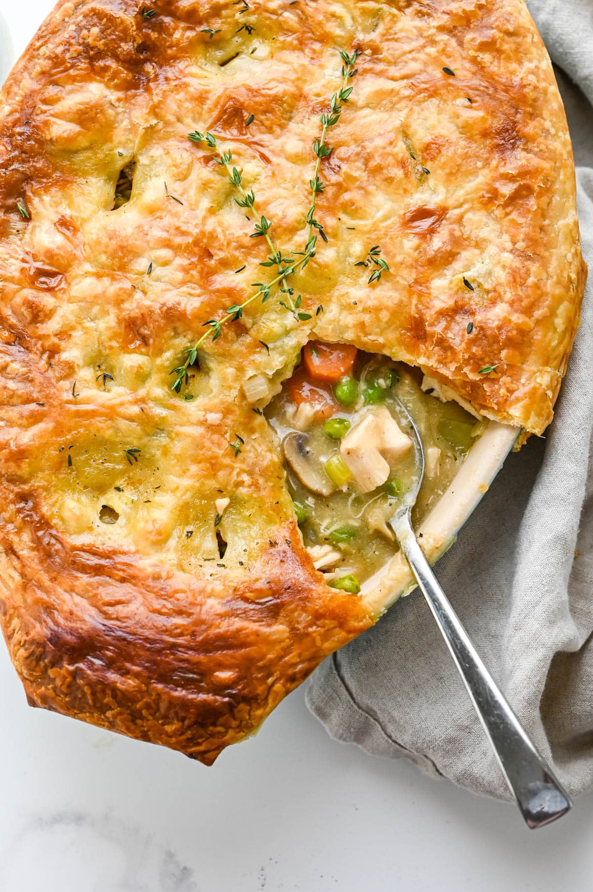 Scooping out Chicken Pot Pie with Puff Pastry Recipe with a spoon.
