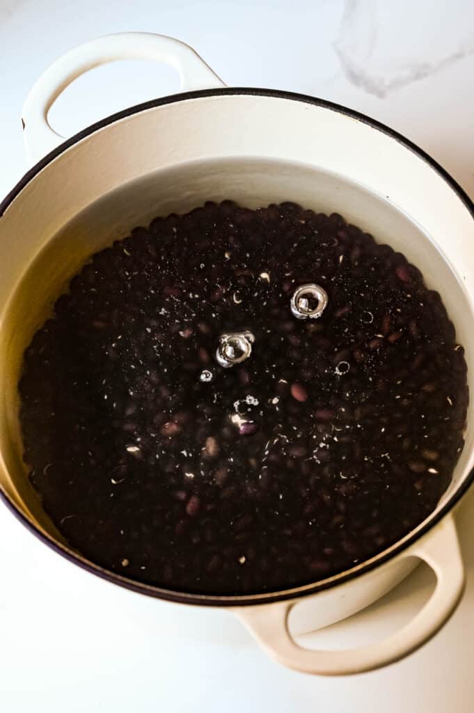 I am covering dried black beans with fresh water to soak them overnight.