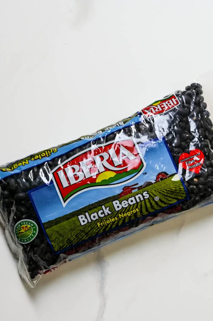 A bag of dried black beans (frijoles negros).