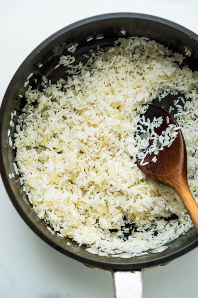 Toast the rice in the hot skillet.