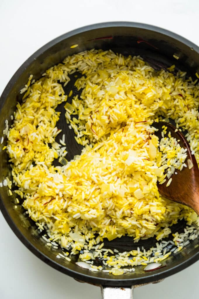 stirring the saffron into the rice.