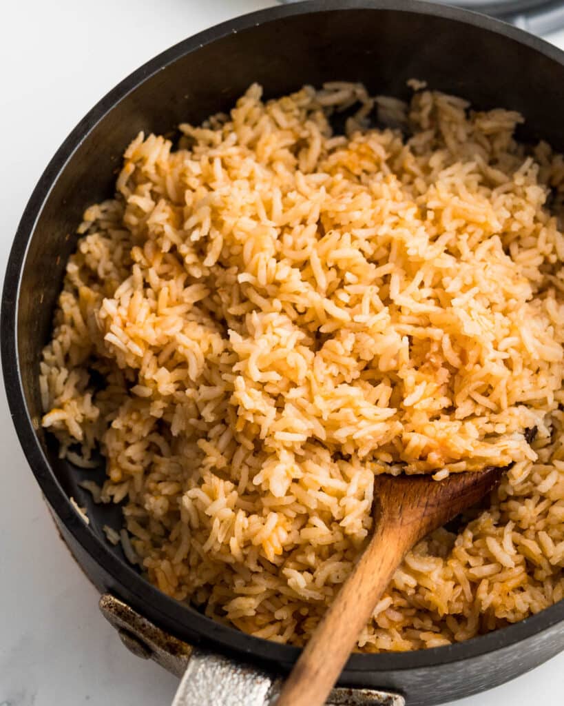 A pot of fluffed cooked rice in a skillet.