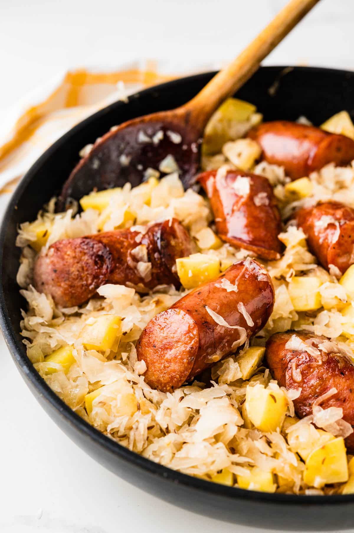 Spooning up the skillet kielbasa and sauerkraut from the pan.