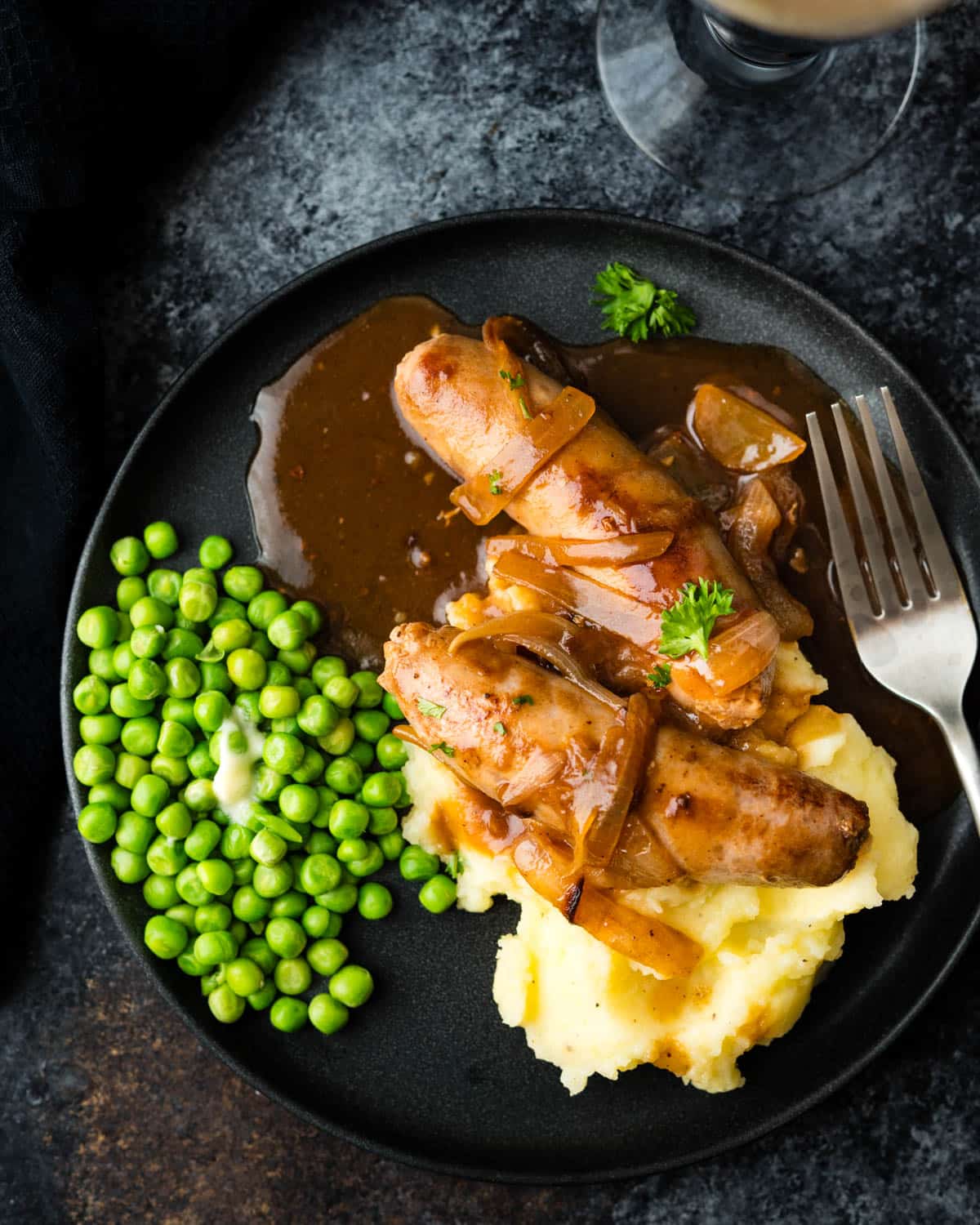 Serving bangers and mash with peas.