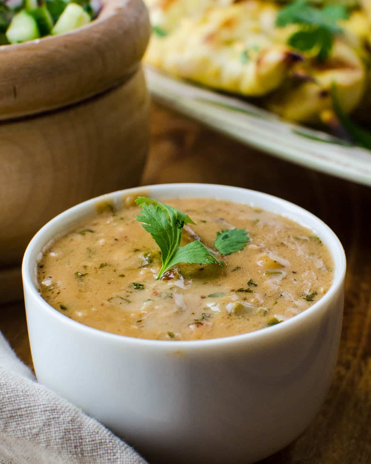 The peanut satay dipping sauce in a white bowl.