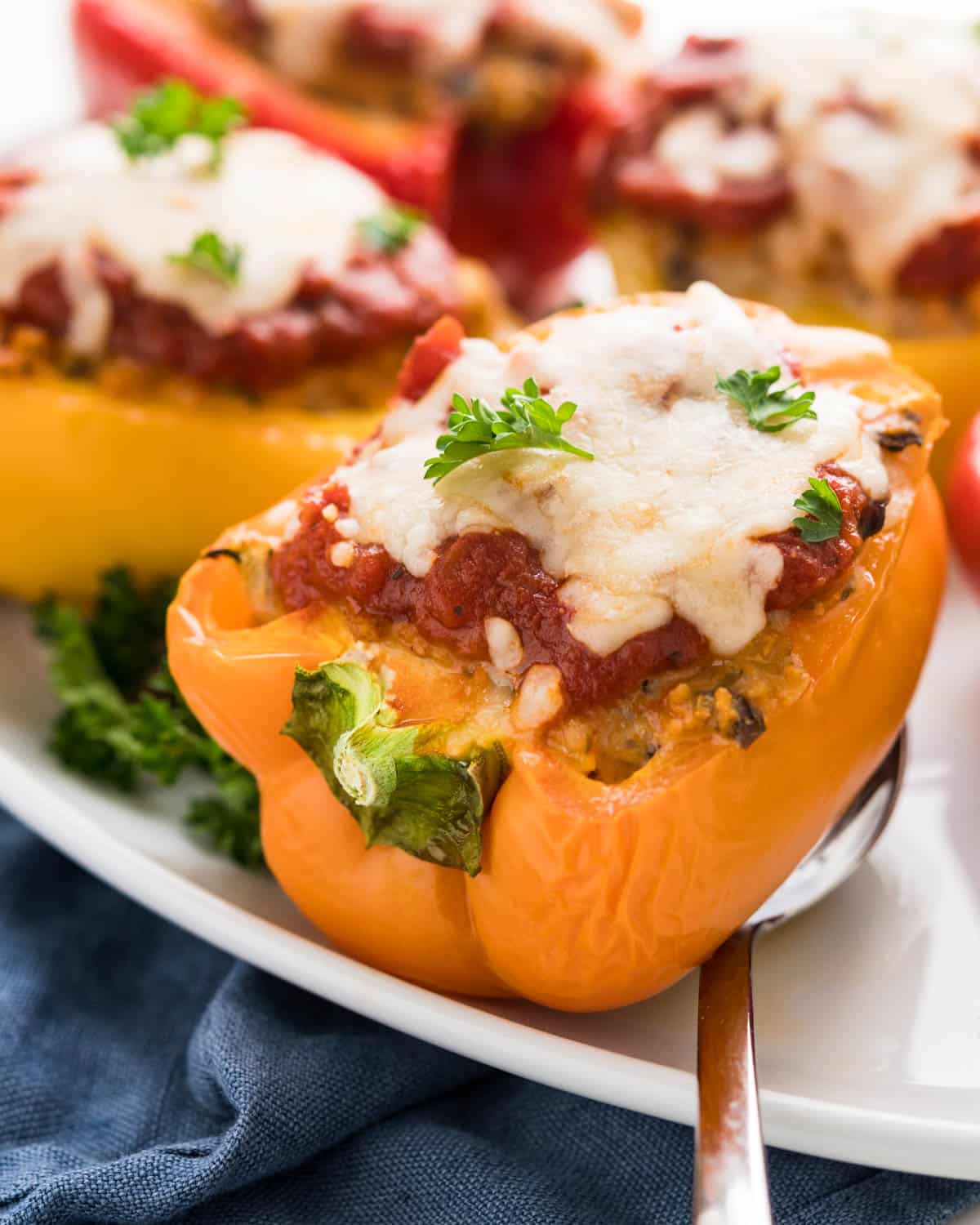 An orange pepper stuffed with seasoned ground chicken and topped with marinara and mozzarella cheese.