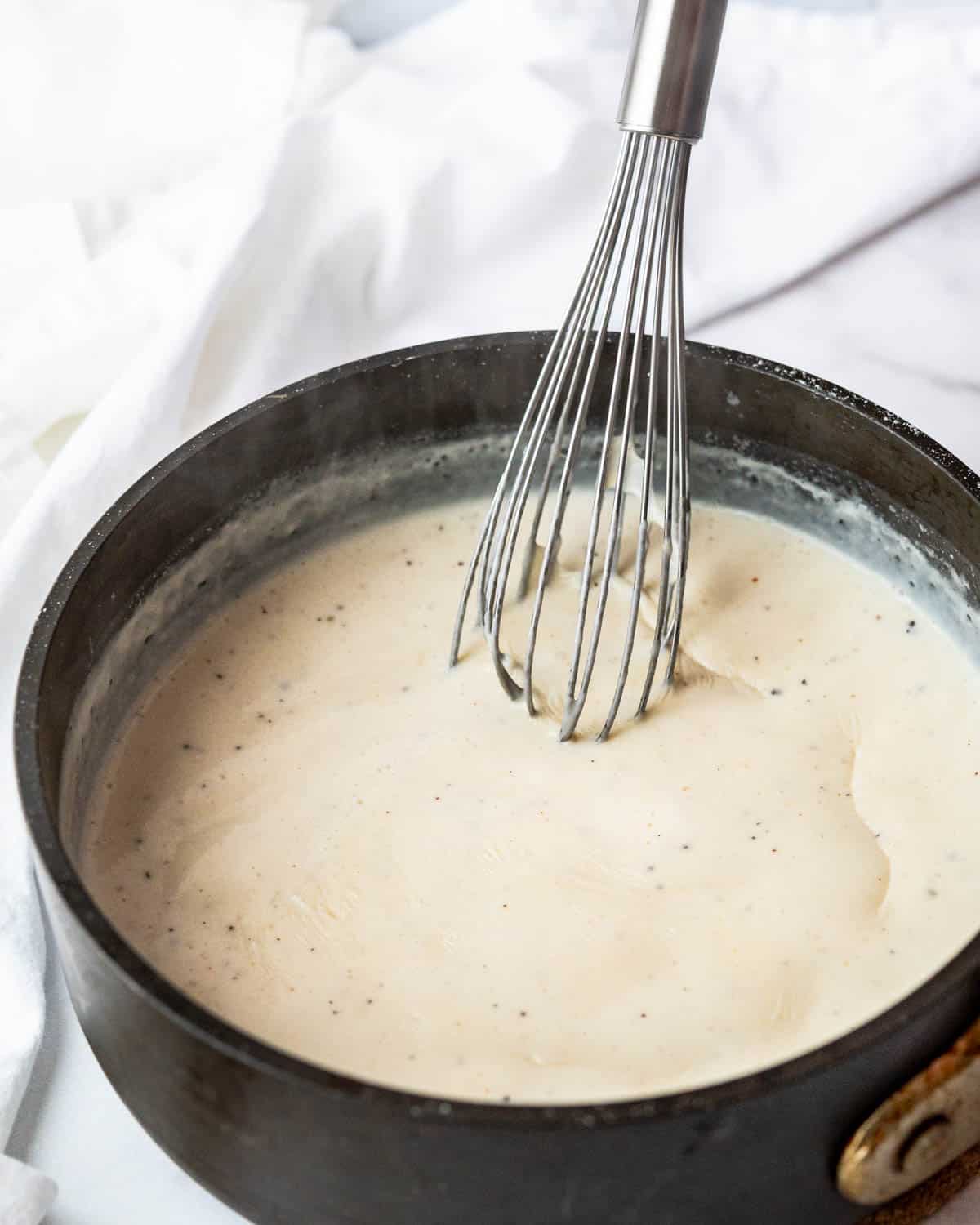 Whisking and cooking the bechamel as it thickens.