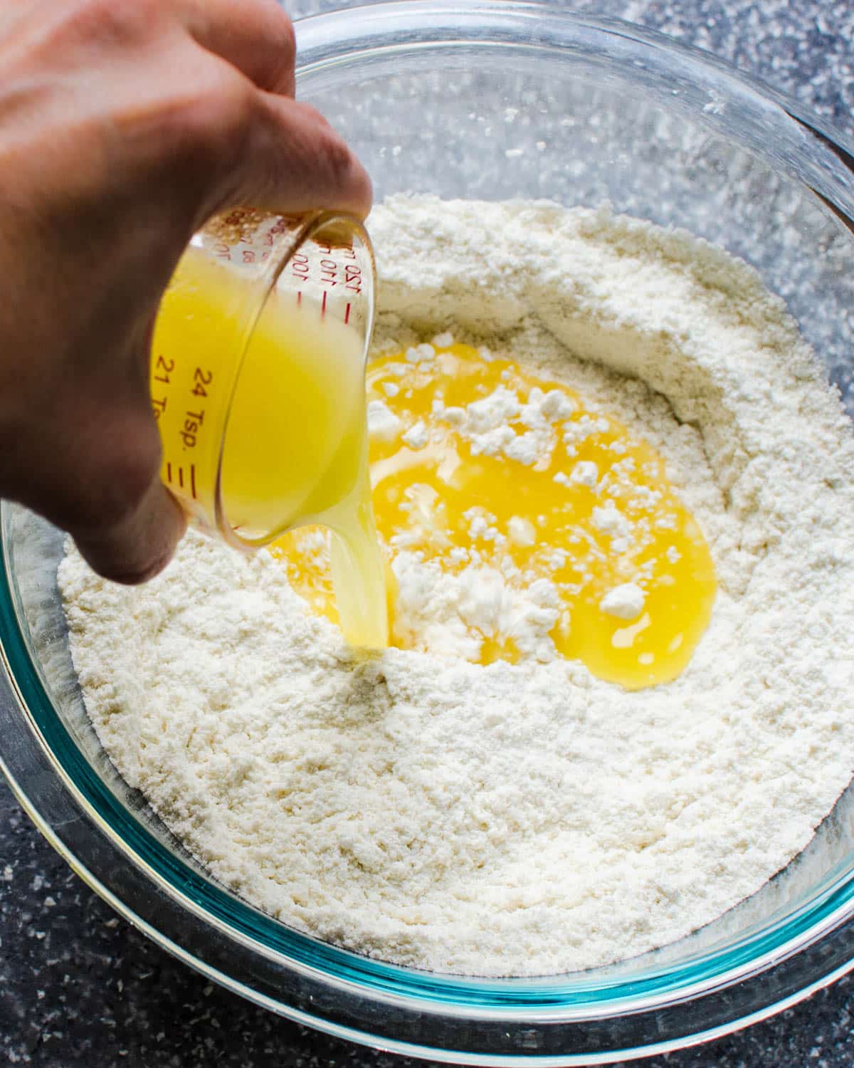 Adding melted butter to the dry ingredients. 