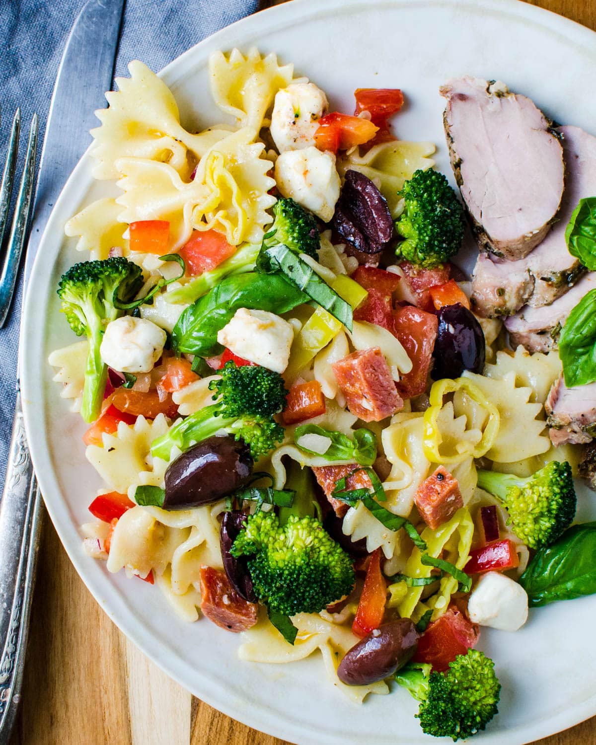 Serving the pasta salad on a plate with sliced chicken.