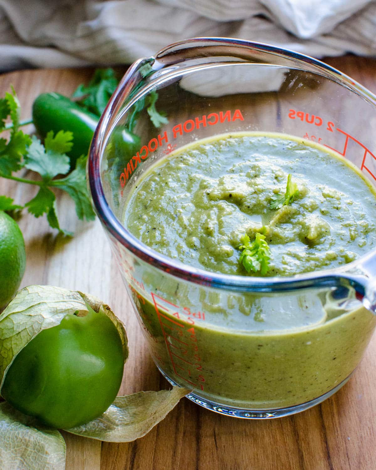 A two-cup glass measure filled with enchilada sauce.